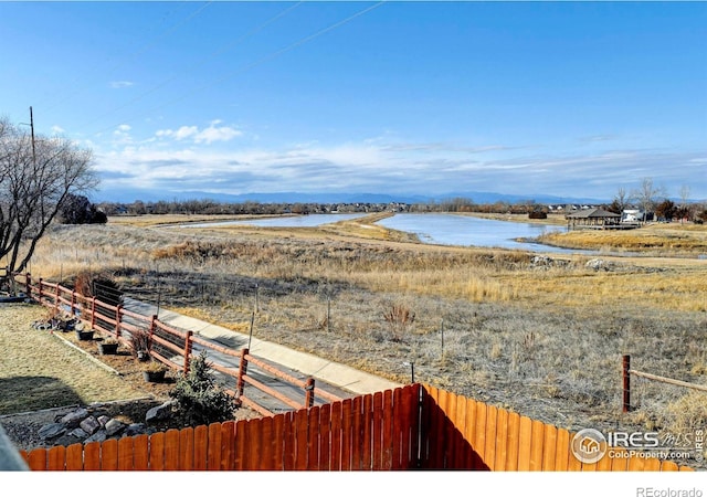 view of yard featuring a water view and fence