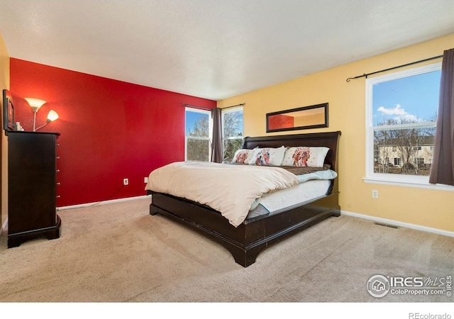 carpeted bedroom with visible vents and baseboards