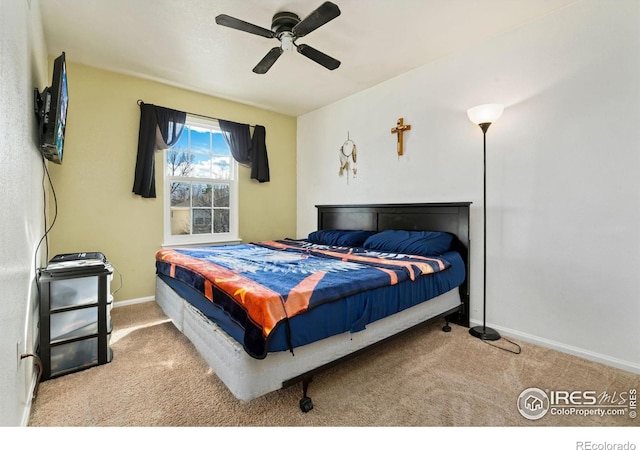 carpeted bedroom with ceiling fan and baseboards