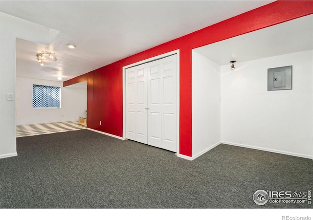 unfurnished room featuring carpet floors, electric panel, and baseboards