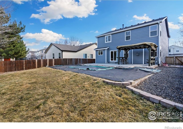 rear view of property featuring a fenced in pool, a patio area, a fenced backyard, and a yard