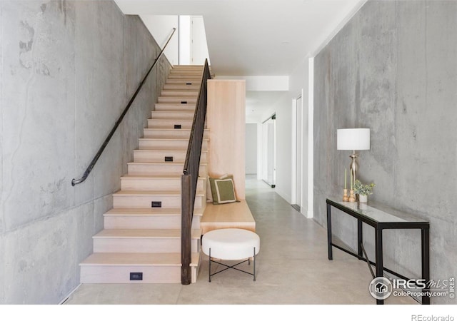 staircase with concrete flooring