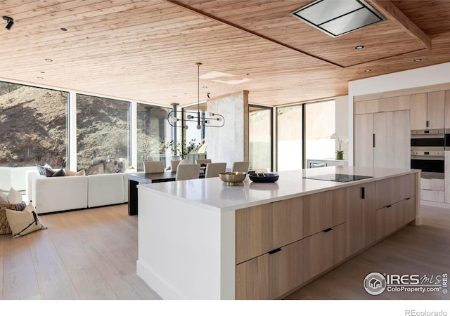 kitchen with wooden ceiling, light brown cabinets, modern cabinets, and light wood finished floors