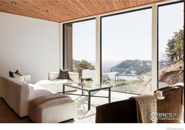 living area with wood ceiling, a wall of windows, wood finished floors, and recessed lighting