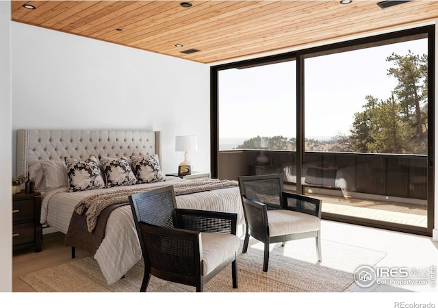 bedroom featuring wooden ceiling, expansive windows, visible vents, and wood finished floors