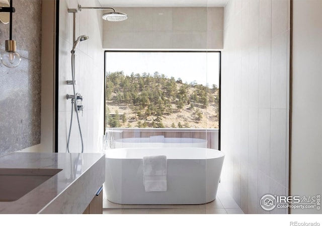 full bathroom with a freestanding bath, tiled shower, and tile walls