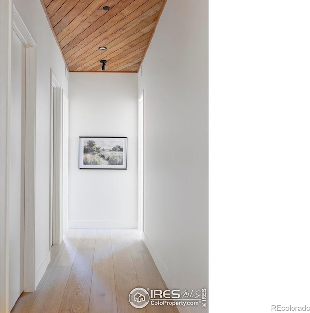 corridor featuring baseboards, wood ceiling, and light wood-style floors