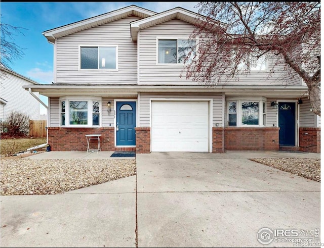 view of front of property with a garage, brick siding, and driveway