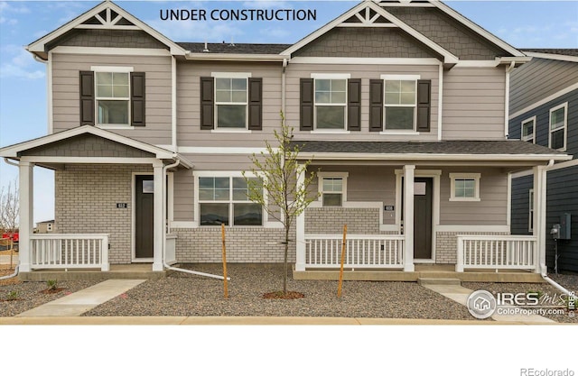 view of front facade featuring covered porch and brick siding