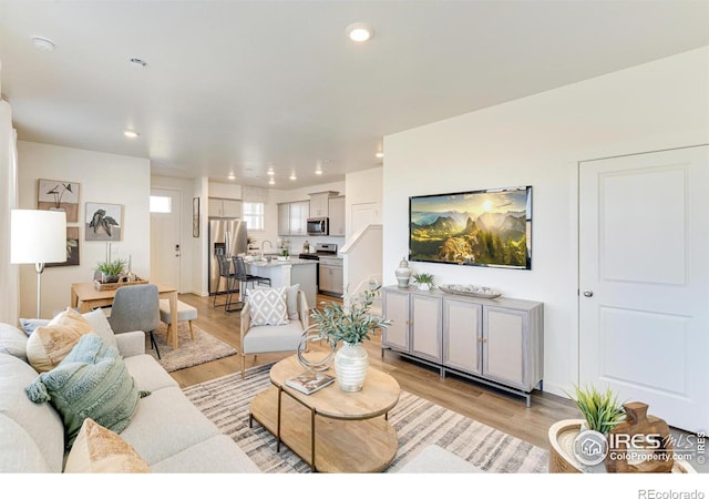 living room with recessed lighting and light wood-style floors