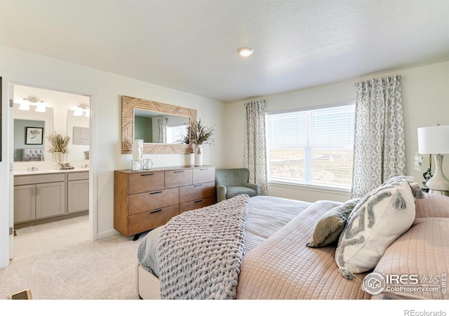 bedroom with light tile patterned floors, connected bathroom, and light colored carpet