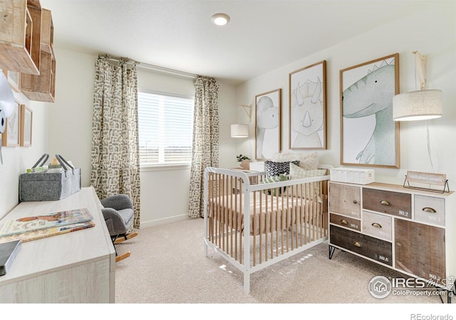 bedroom with carpet floors, a crib, and baseboards