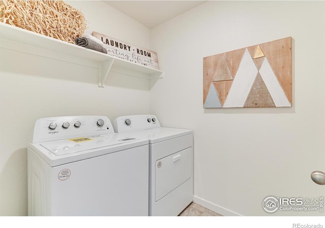 washroom featuring laundry area, washing machine and dryer, and baseboards