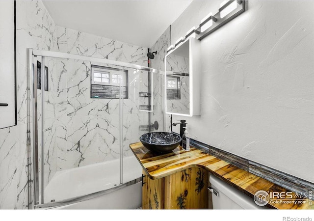 bathroom featuring vanity and a marble finish shower