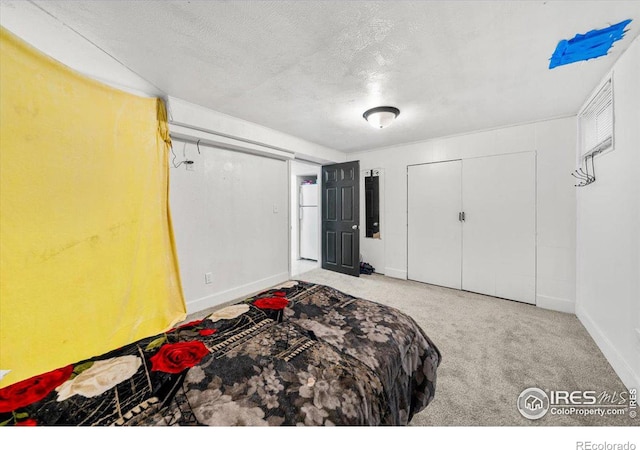 bedroom featuring a textured ceiling, carpet floors, freestanding refrigerator, and baseboards