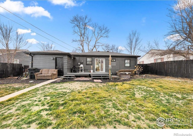 rear view of property with a fenced backyard, a yard, and a deck