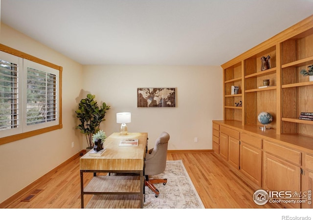 office space with baseboards, visible vents, and light wood finished floors