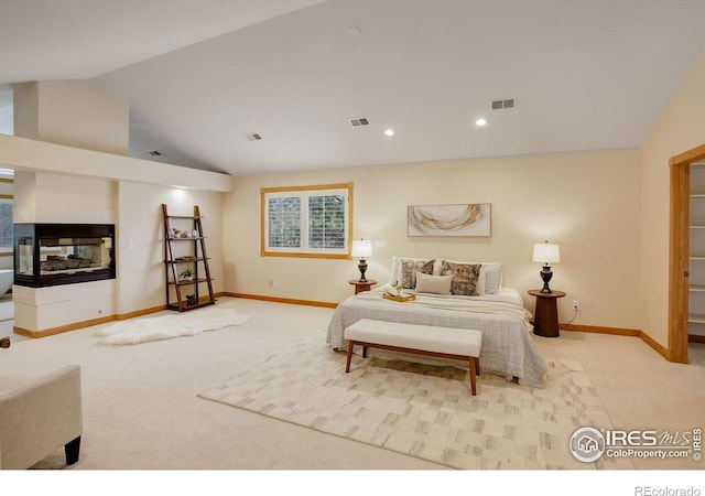 bedroom with vaulted ceiling, light carpet, a multi sided fireplace, and visible vents