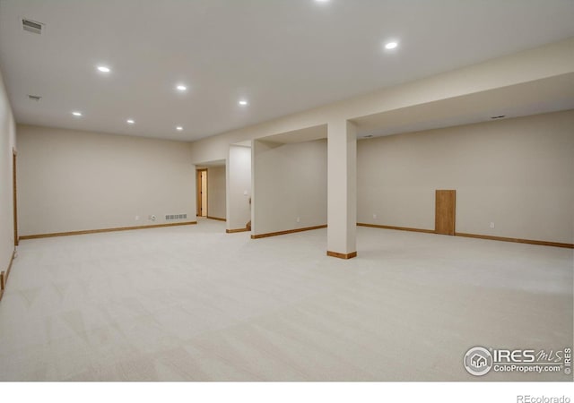 finished basement with light carpet, visible vents, and recessed lighting