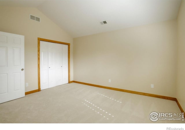 unfurnished bedroom with carpet floors, baseboards, visible vents, and vaulted ceiling