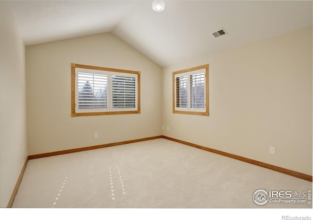 unfurnished room featuring lofted ceiling, carpet floors, plenty of natural light, and visible vents