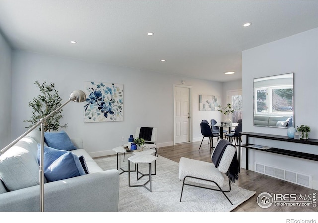 living room featuring recessed lighting, visible vents, baseboards, and wood finished floors