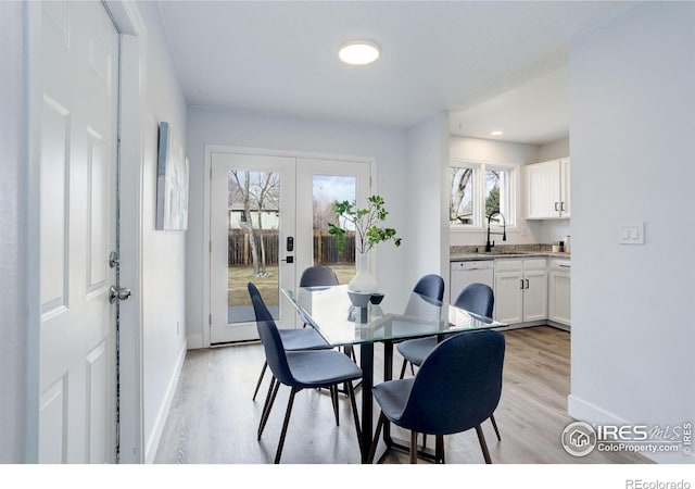 dining room featuring baseboards, french doors, and light wood-style floors