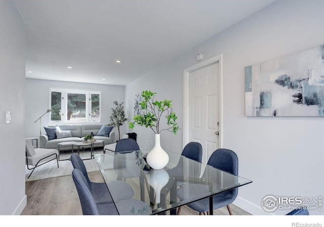 dining area with baseboards, wood finished floors, and recessed lighting