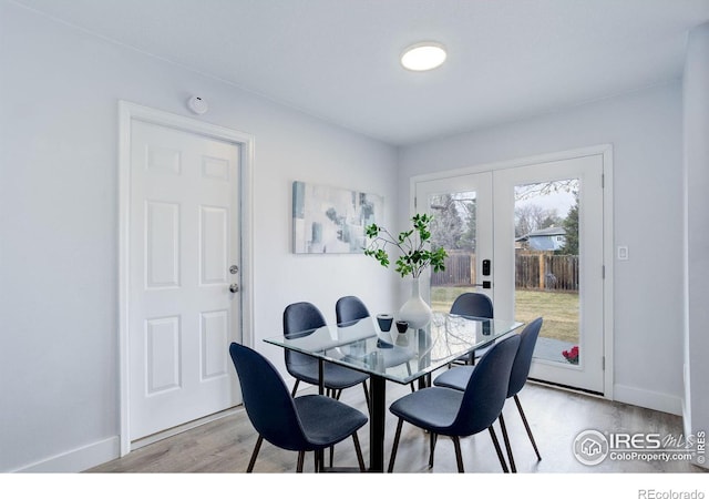 dining room with light wood-type flooring, french doors, and baseboards