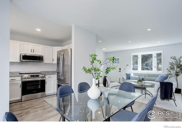 dining area featuring light wood-type flooring and recessed lighting