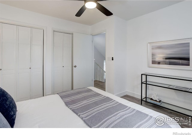 bedroom with ceiling fan, baseboards, multiple closets, and wood finished floors