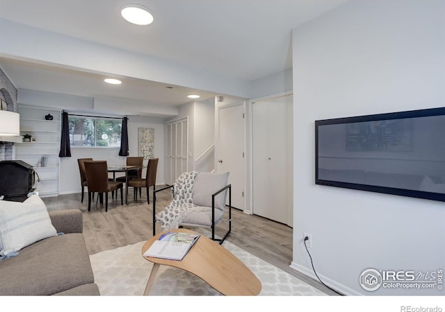 living room featuring baseboards, light wood finished floors, and recessed lighting