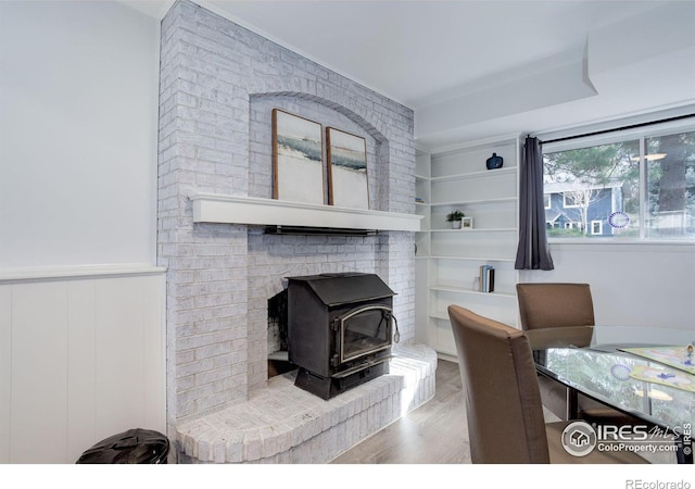 interior space with a wood stove, wainscoting, and wood finished floors