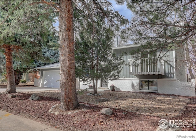 view of front of home featuring driveway, brick siding, and an attached garage