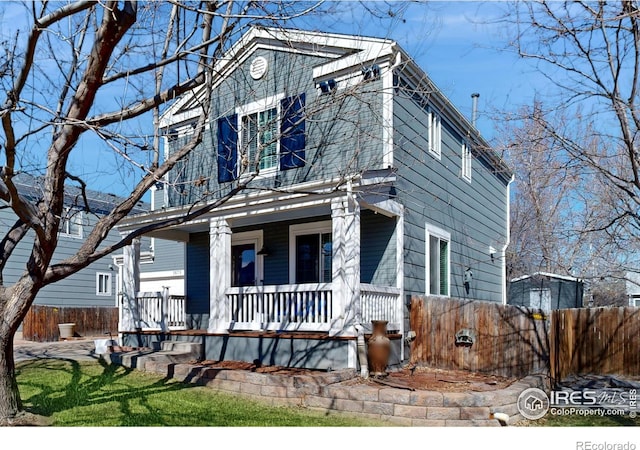 view of front of property with covered porch and fence