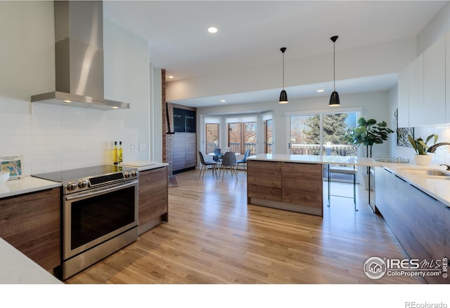 2425 Waneka Lake Trl, Lafayette, CO 80026 - kitchen featuring wall chimney exhaust hood, electric range, modern cabinets, a sink, and brown cabinets