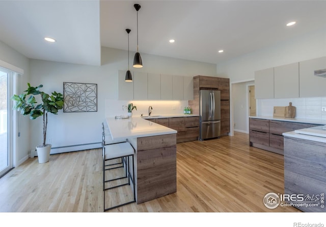 2425 Waneka Lake Trl, Lafayette, CO 80026 - kitchen with freestanding refrigerator, a sink, modern cabinets, tasteful backsplash, and a peninsula