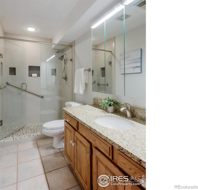 2425 Waneka Lake Trl, Lafayette, CO 80026 - bathroom featuring vanity, toilet, a stall shower, and tile patterned floors