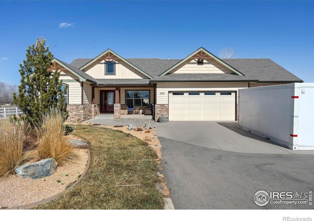 view of front of house featuring an attached garage, stone siding, fence, and concrete driveway