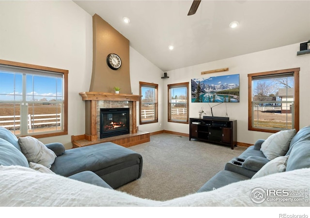 living area with a healthy amount of sunlight, a tiled fireplace, and carpet flooring