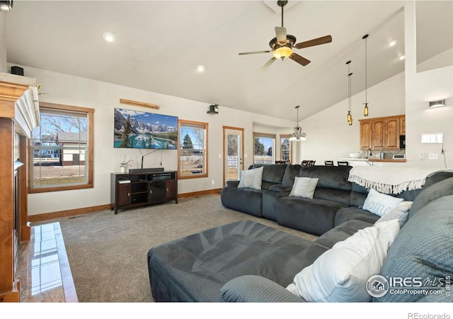 carpeted living area featuring recessed lighting, baseboards, high vaulted ceiling, and ceiling fan with notable chandelier