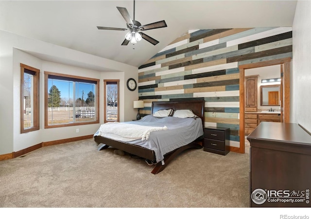 bedroom with an accent wall, light carpet, vaulted ceiling, wooden walls, and baseboards