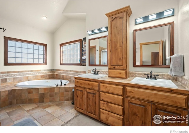 bathroom with lofted ceiling, a garden tub, double vanity, and a sink