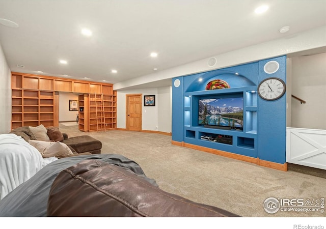 carpeted living room with built in shelves, recessed lighting, and baseboards