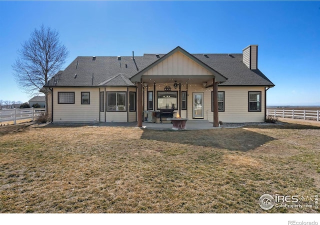 rear view of house with a patio, a chimney, a lawn, a ceiling fan, and fence