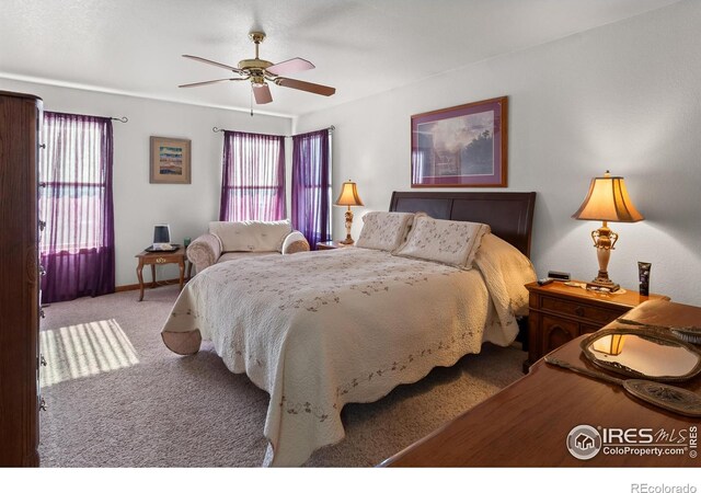 bedroom featuring carpet floors, multiple windows, and a ceiling fan