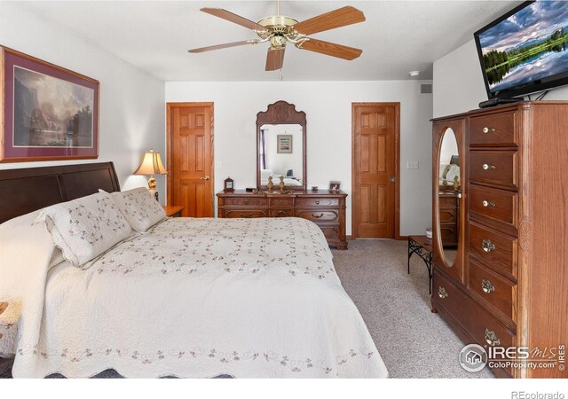 carpeted bedroom featuring ceiling fan and visible vents