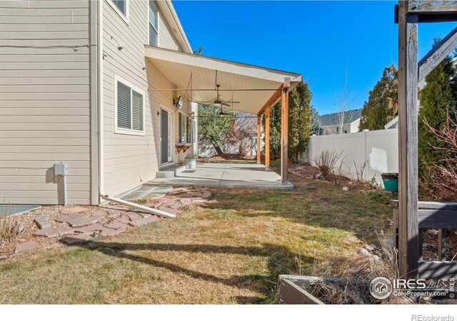 view of yard with a ceiling fan, a patio area, and fence