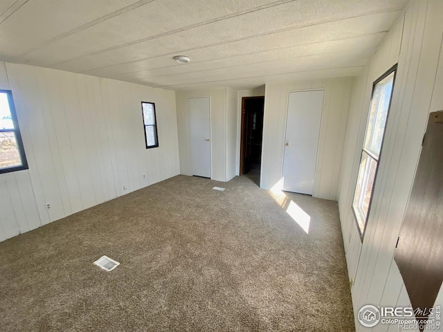 unfurnished bedroom with carpet floors and visible vents