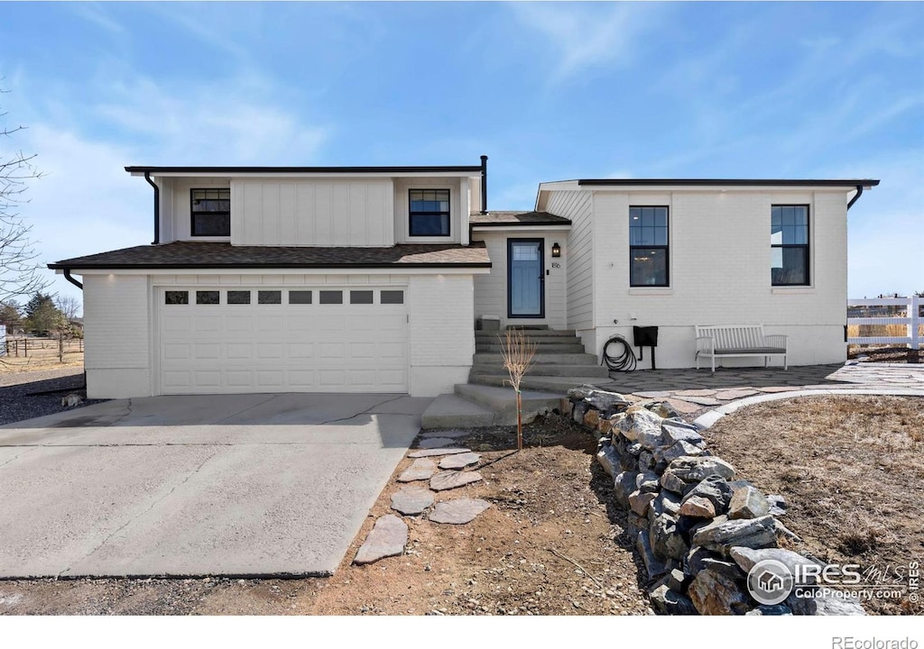 view of front of property with concrete driveway, fence, and an attached garage